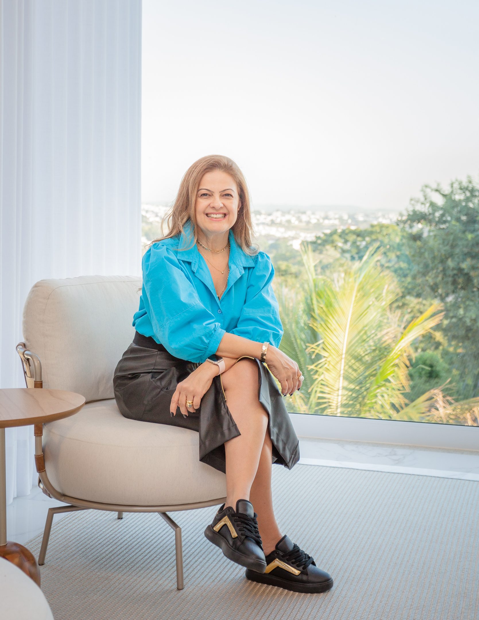 Fabiana Zanchetta sentada em uma poltrona sorrindo